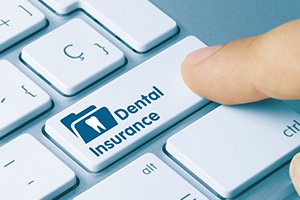 Finger pressing a key that says “Dental Insurance”