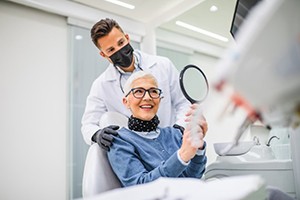 Woman smiling after receiving her dental implant restoration