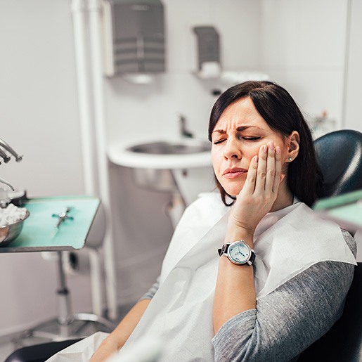 Woman in treatment chair experiencing toothache