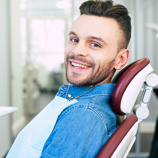 Patient smiling while sitting in dentist treatment chair