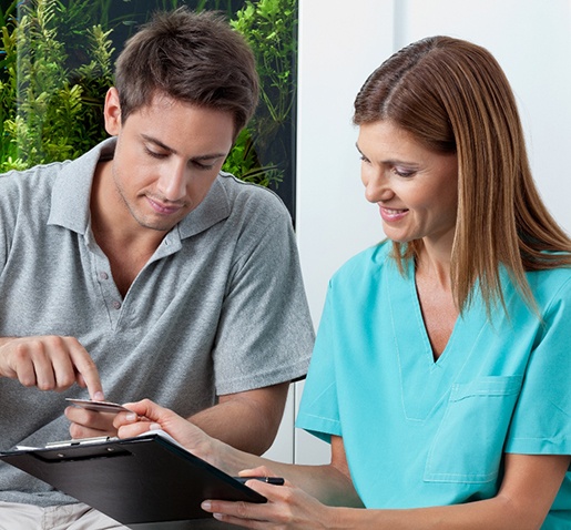 Dental staff member discussing payment with patient