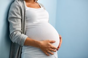 Pregnant woman with hands on stomach