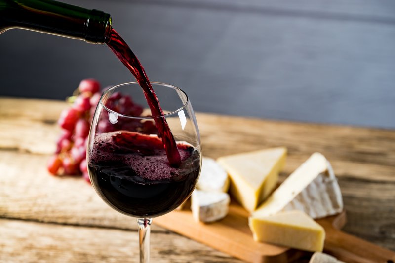 A glass of red wine being poured