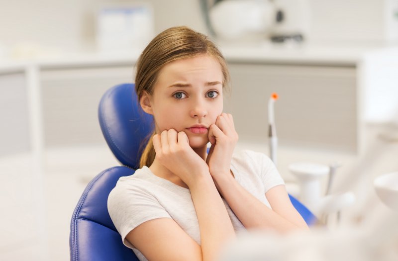 A girl in a dentist’s chair suffering from dental anxiety